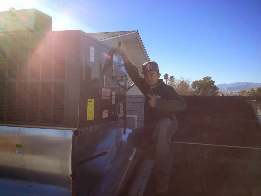 HVAC technician performing AC Tune-Up on a rooftop unit in Cresskill