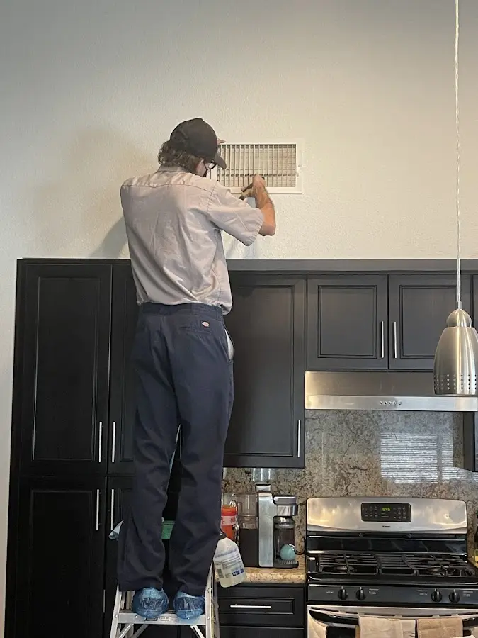 Technician inspecting an air vent during HVAC service in Cresskill